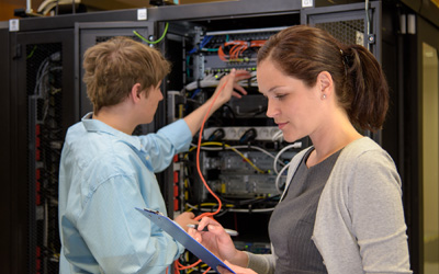 Team of IT specialists in datacenter working by network servers